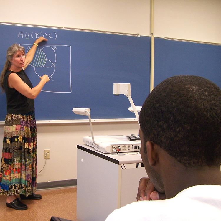 teacher explaining math problem on the board