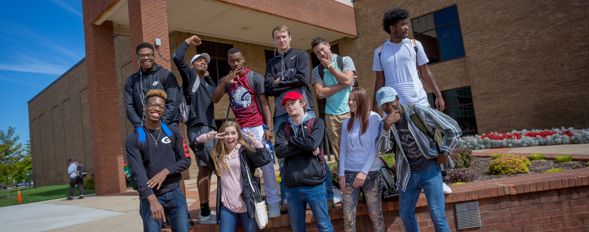 11 students posing for a picture in front of the Thigpen library on the Gallatin Campus
