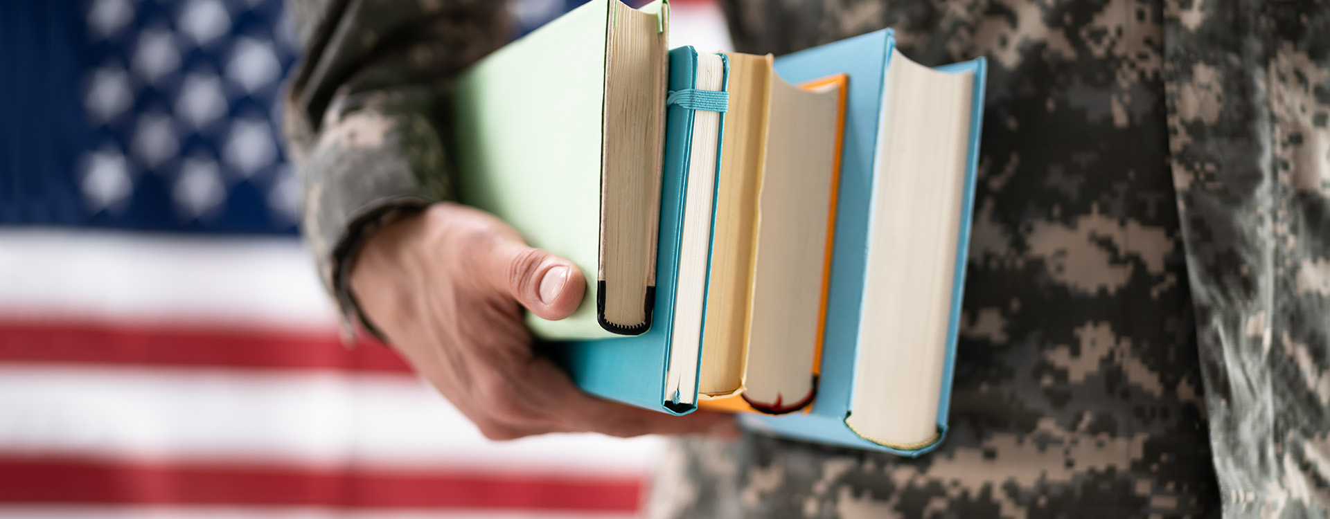 military-affliated student holding his books