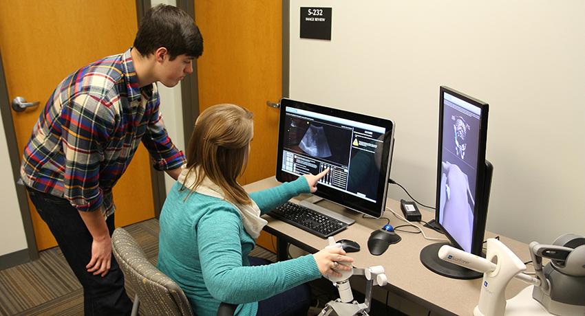 Pictured: Connor Hansford watches as Denee Kelley simulates a scan of the liver using equipment at Vol State.